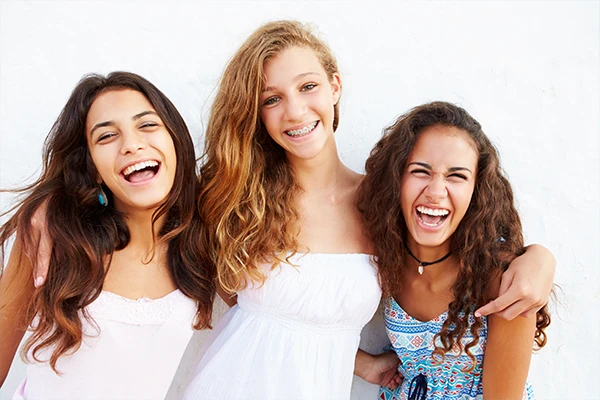 Three girls smiling in the picture with one girl flaunting her smile with braces Three girls smiling in the picture with one girl flaunting her smile with braces